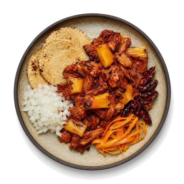 Al Pastor plated with pork, orange peel, chili