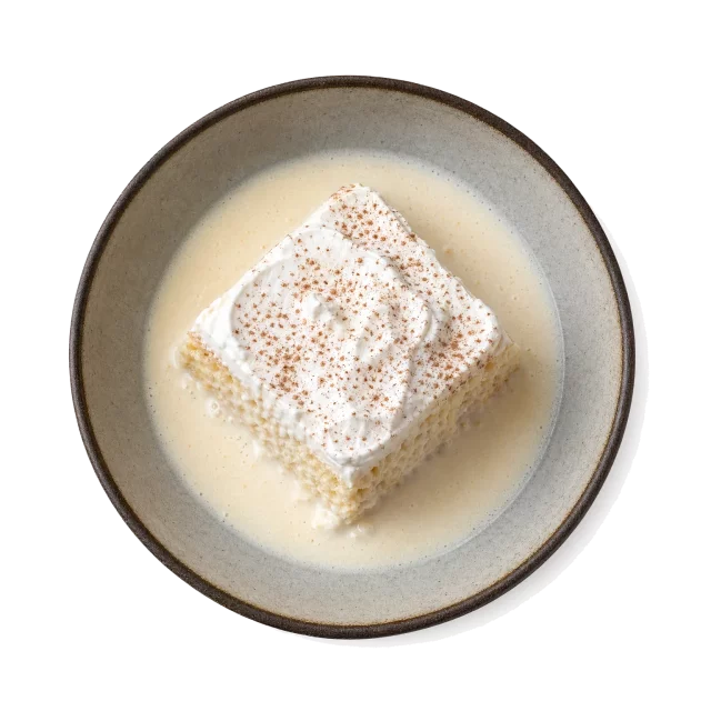 Tres Leches Cake plated with milk, cream, sugar