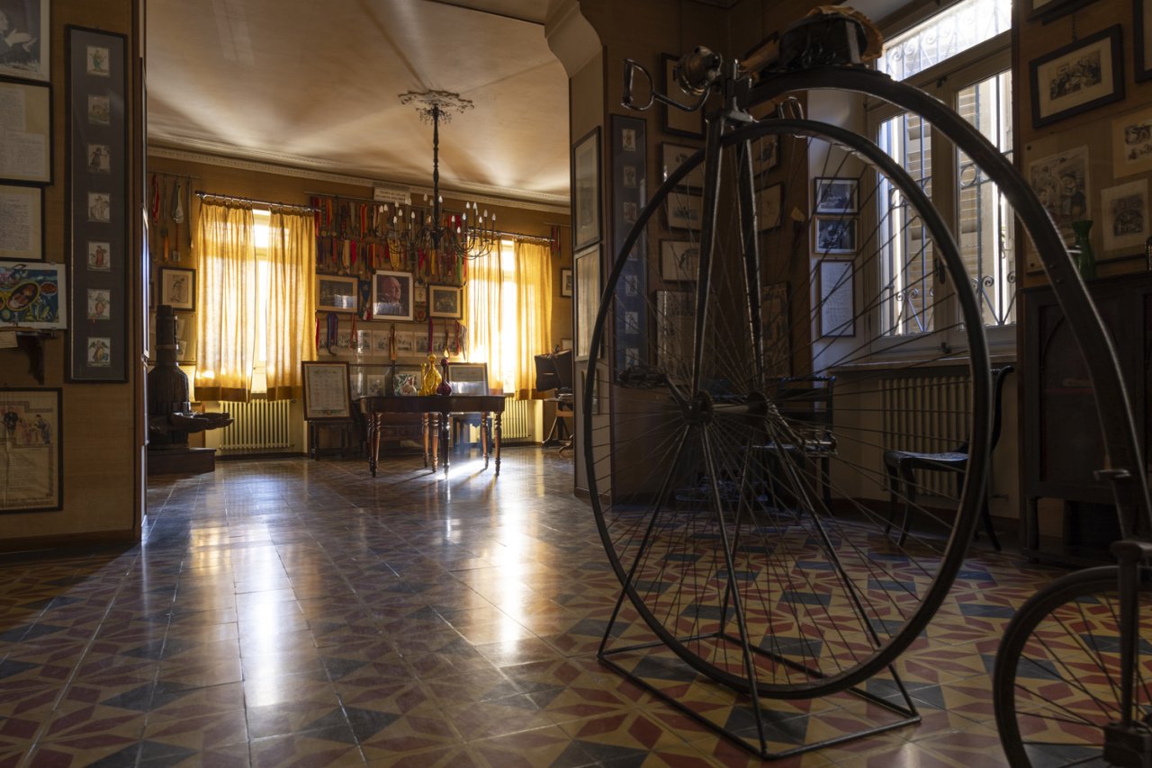 A room of the Bersano museum at Nizza Monferrato, with a penny-farthing bicycle and framed prints