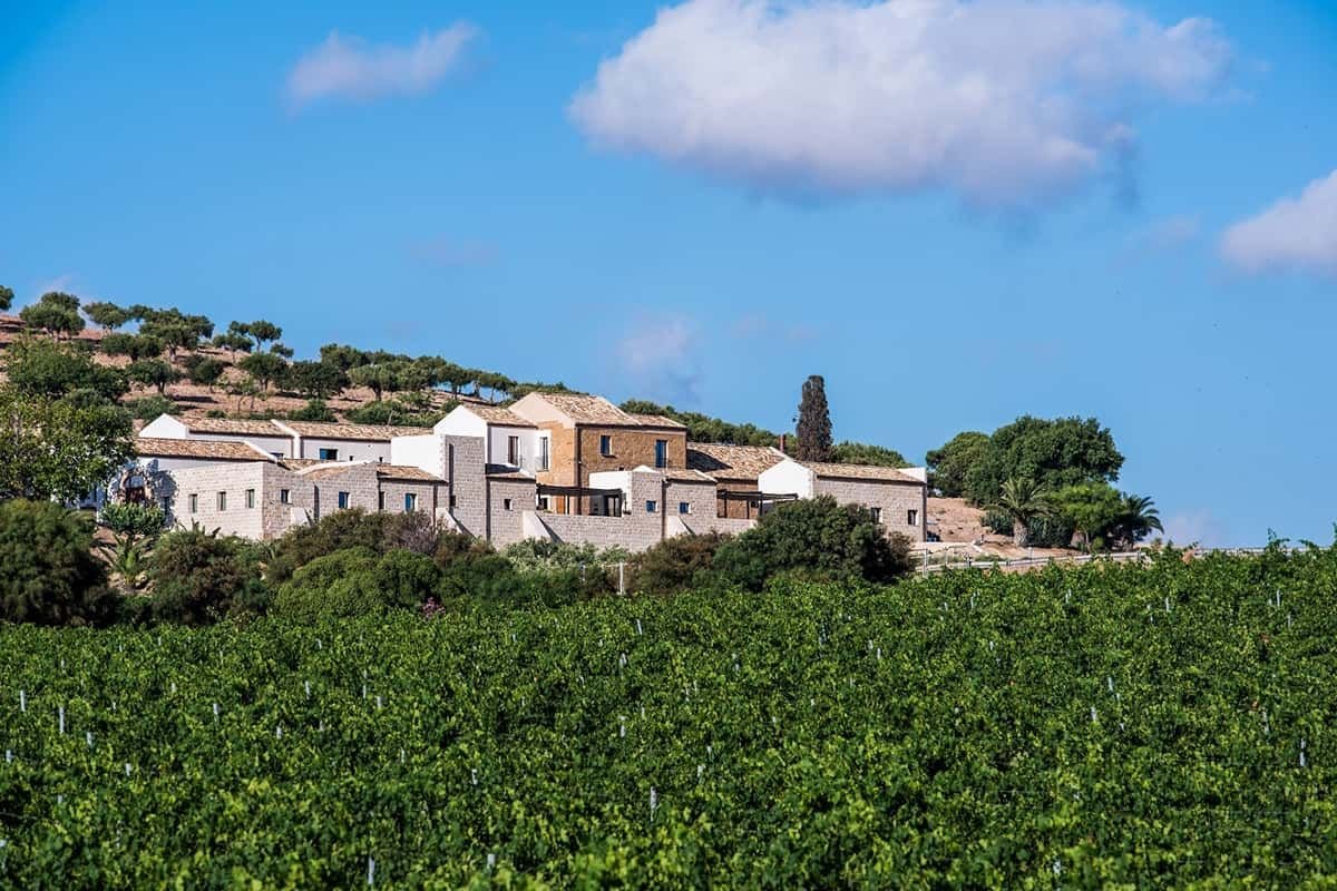 Stone farm buildings of Baglio Sor&igrave;a standing above a vineyard on Firriato's estate near Trapani
