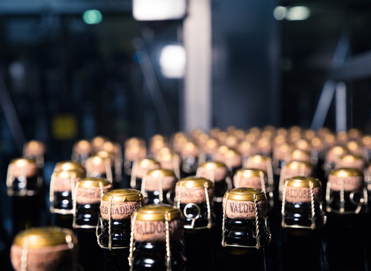 Bottles of Valdo sparkling wine with gold foil caps in the cellar