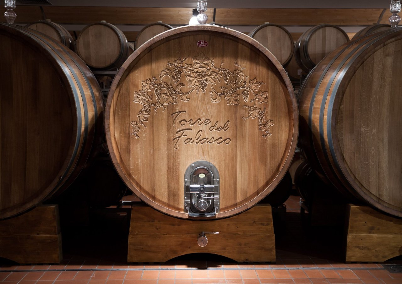 A large oak cask carved with the Torre del Falasco name in the Cantina Valpantena cellar