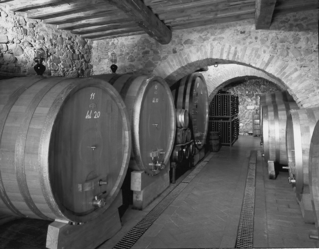 Large oak casks in the stone-vaulted cellar at Le Chiuse, in black and white