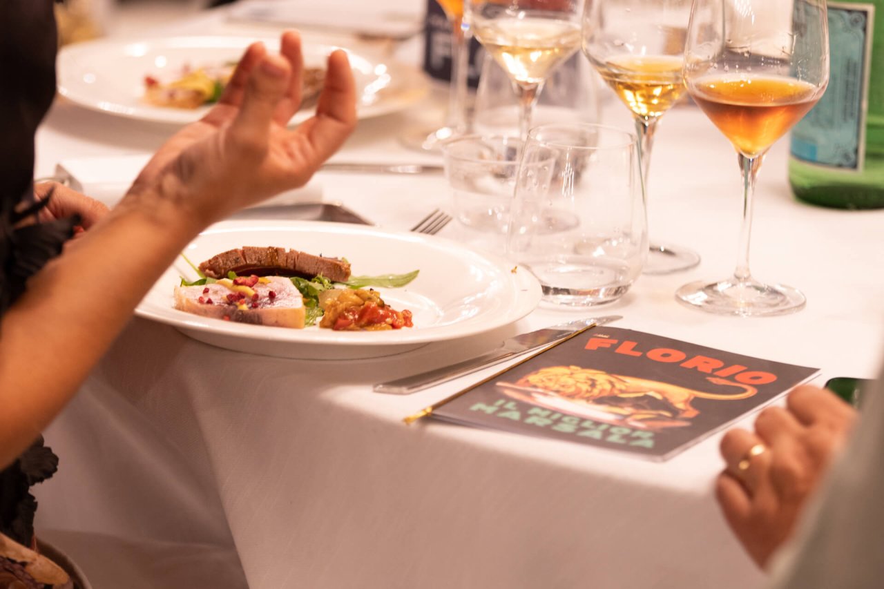 Glasses of Florio Marsala beside small plates at a tasting table in the Florio cellars