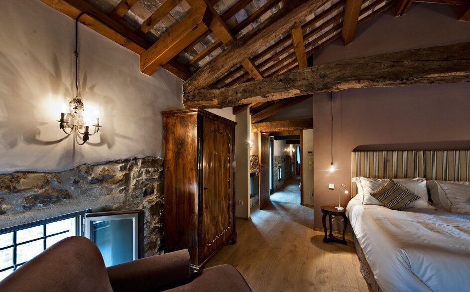 A bedroom under old wooden beams at the Castello di Buttrio hotel