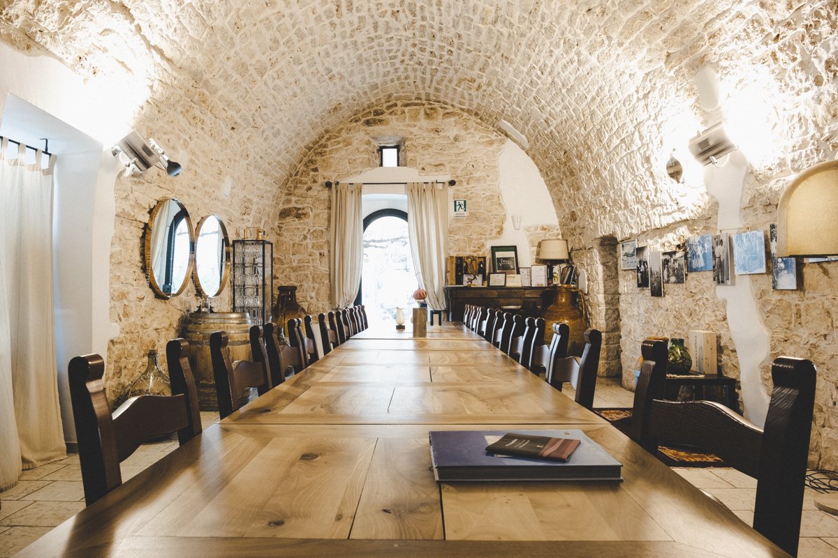 The vaulted stone hall of the Polvanera farmhouse with a long wooden table set for tastings
