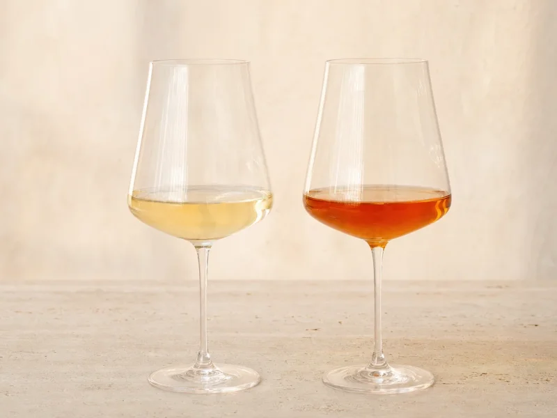 A pale gold Friulian white beside a deep amber skin-contact orange wine, showing the colour difference.