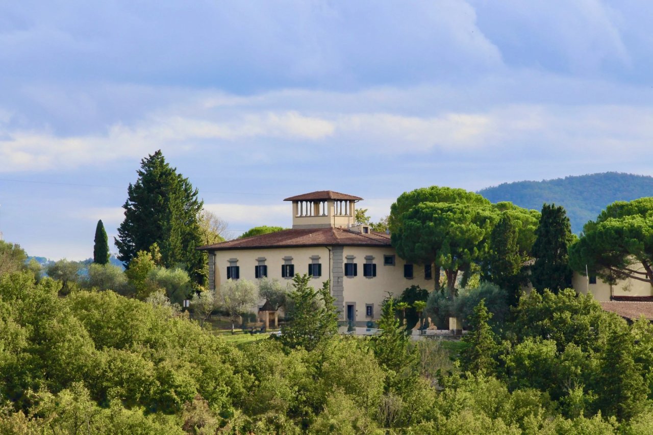 The villa at Corte di Valle, with its small rooftop tower, among umbrella pines and woods near Greve in Chianti