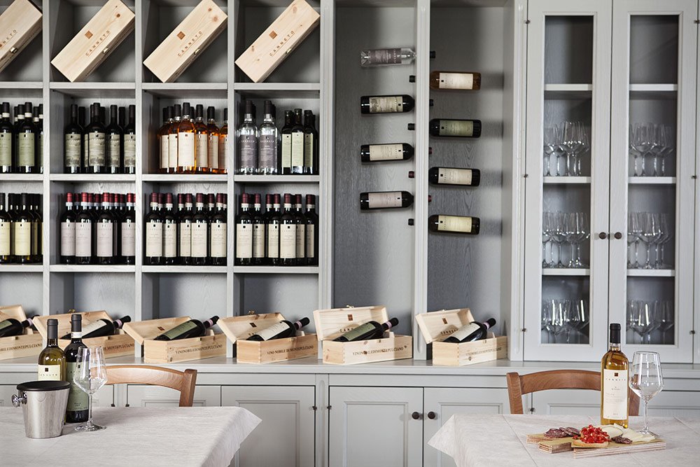 The tasting room at Canneto, with shelves of bottles and wooden wine boxes along the wall