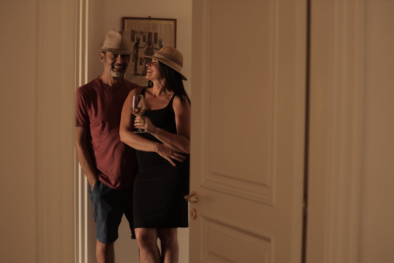 Nativ founders Mario Ercolino and Roberta Pirone smiling in a doorway with a glass of white wine
