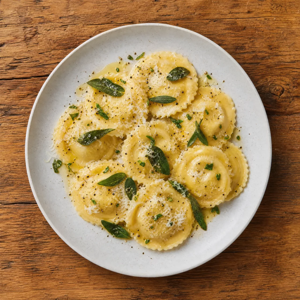 Italian ravioli with sage butter and parmesan on a rustic wooden table