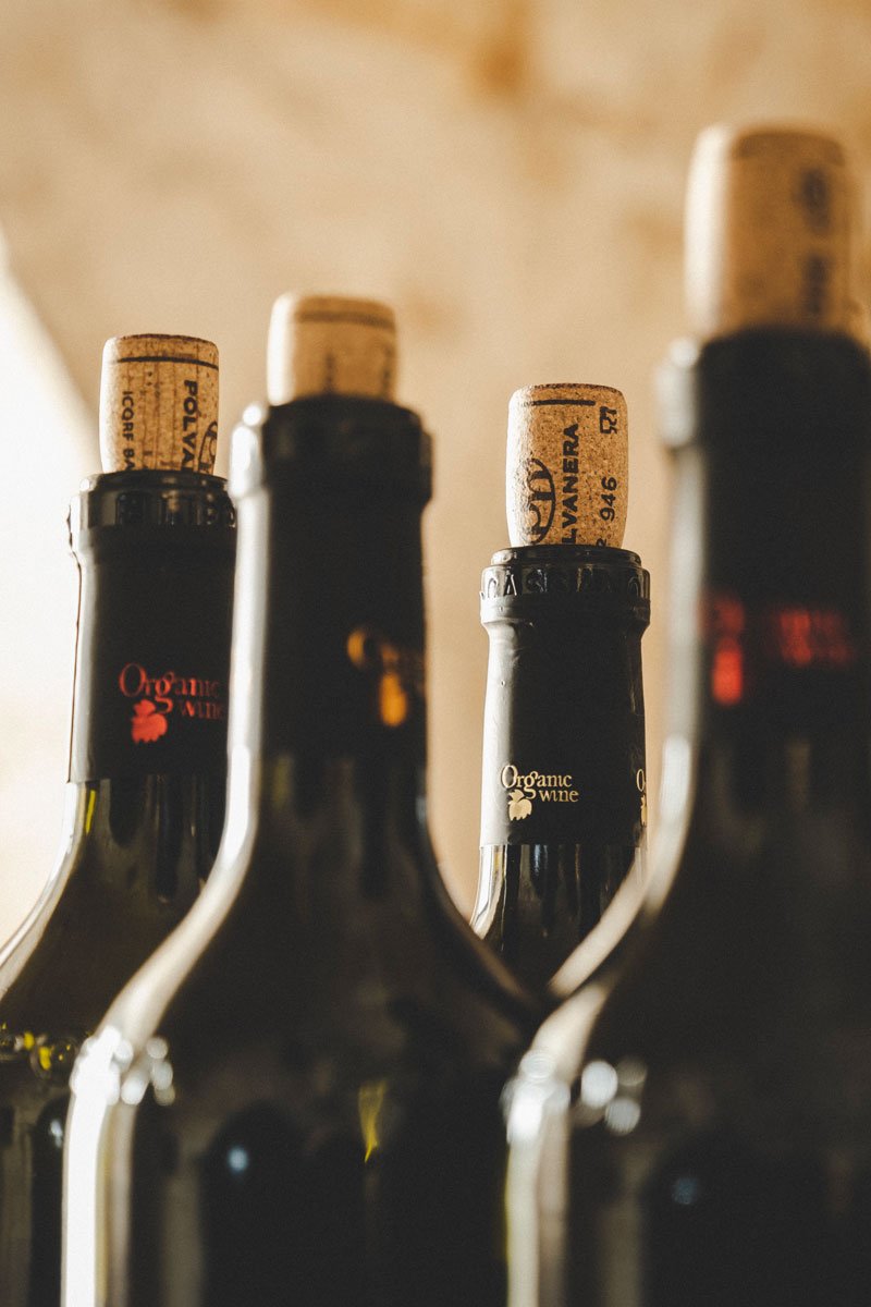 Necks of Polvanera bottles with corks and Organic Wine capsules