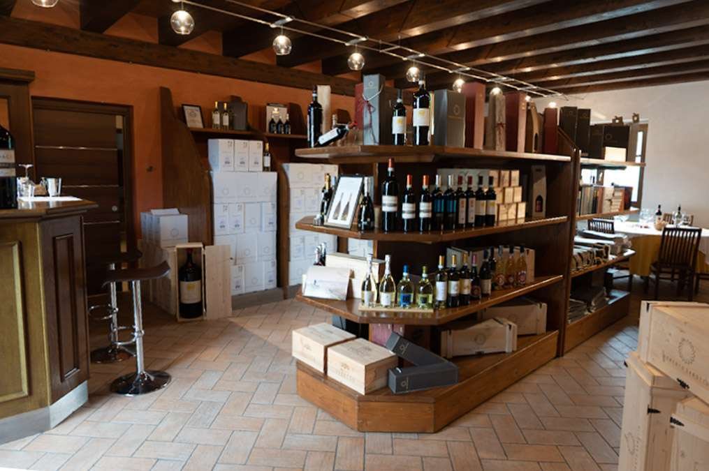 Bottles and wooden cases on the shelves of the Roberto Sarotto cellar shop at Neviglie
