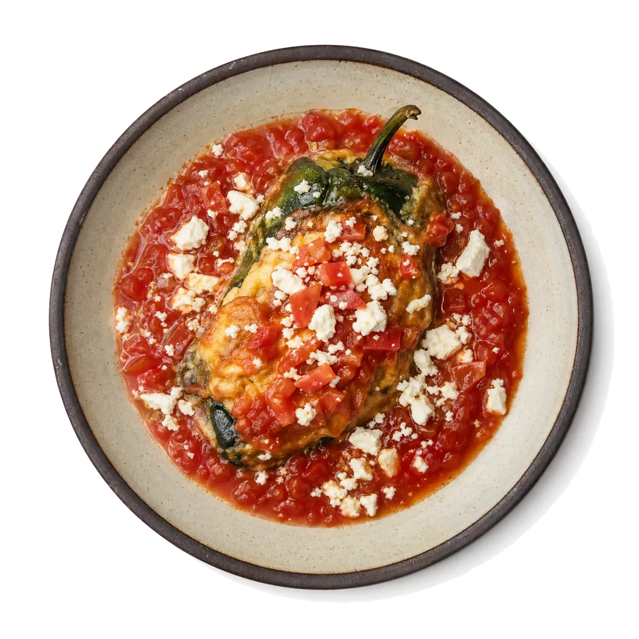 Chiles Rellenos plated with bell pepper, queso fresco, tomato