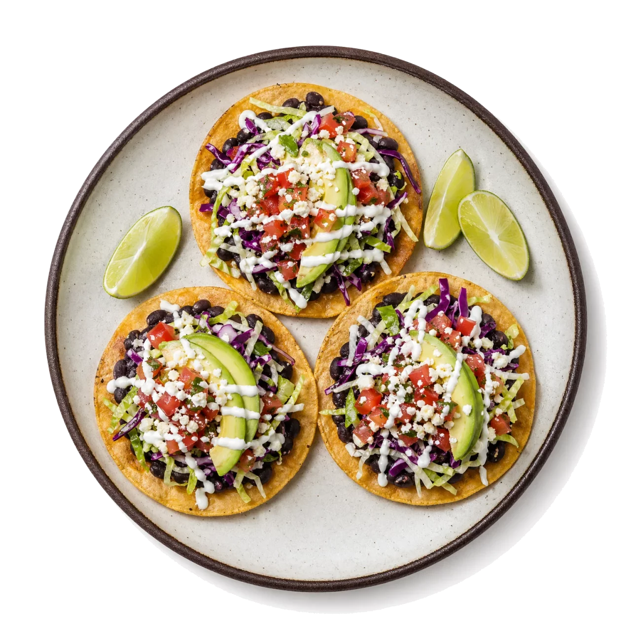 Tostadas plated with corn tortilla, black beans, tomato