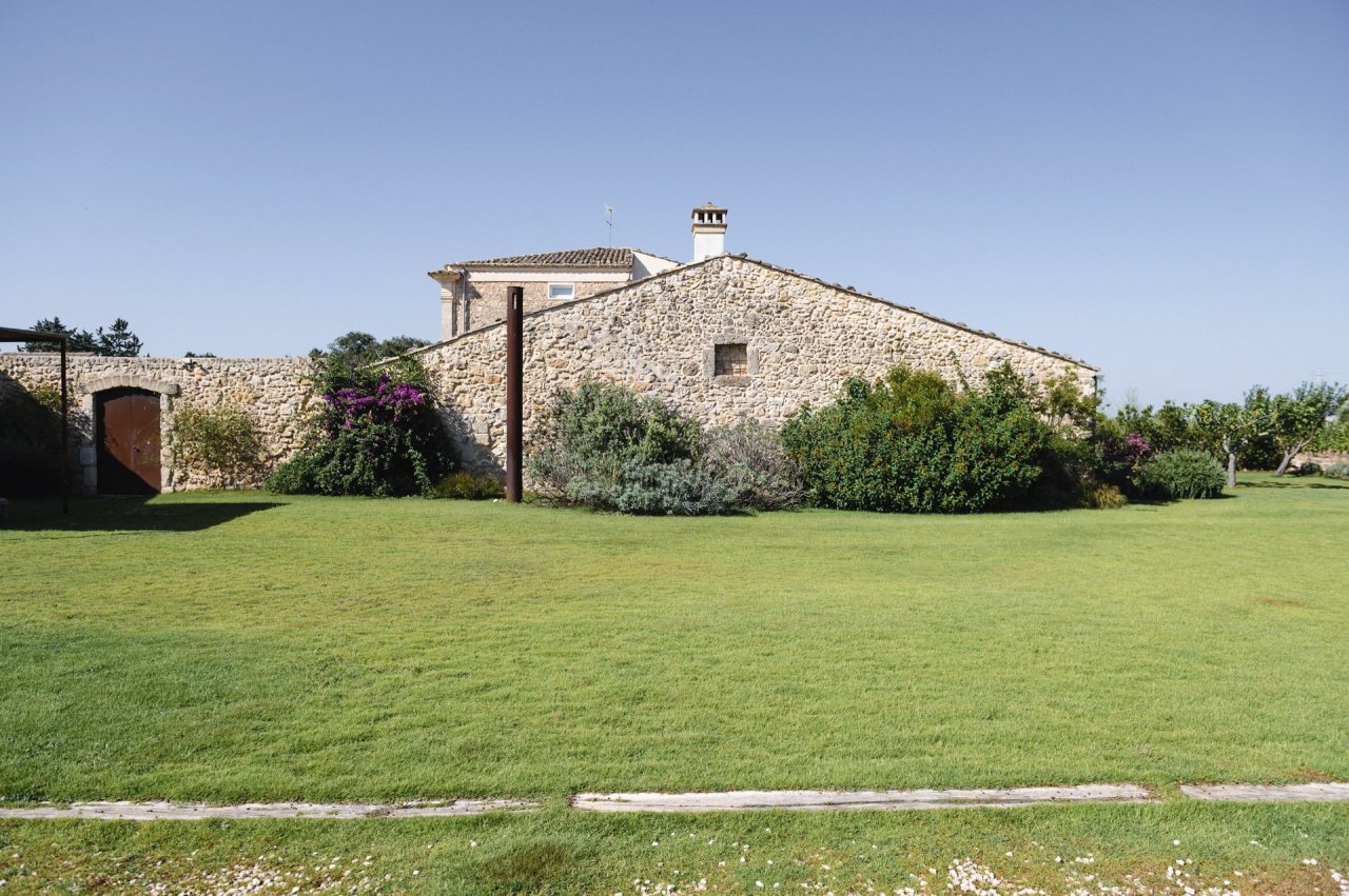Stone farm buildings and a lawn at Arianna Occhipinti's estate outside Vittoria