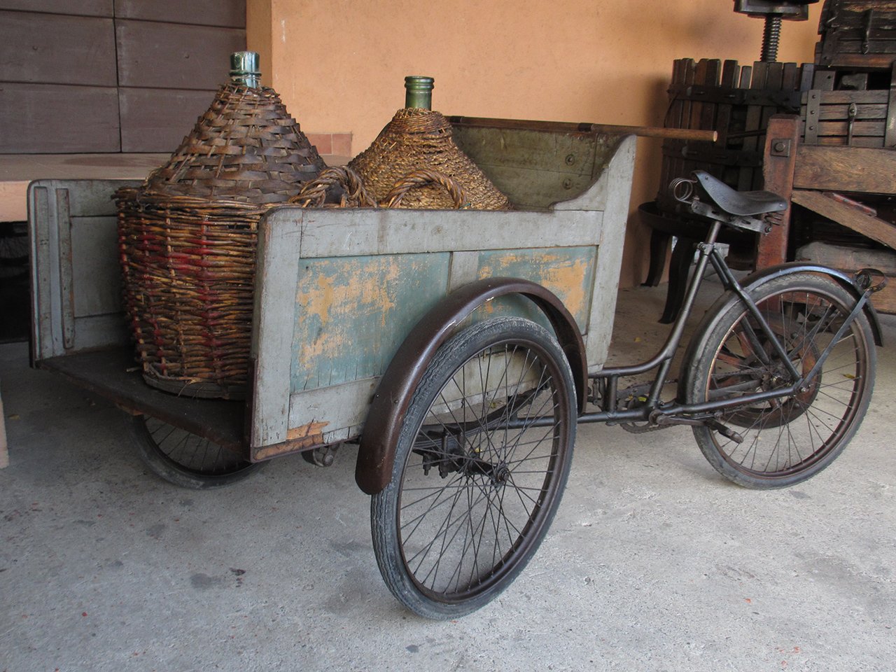 A transport tricycle loaded with wicker-covered wine demijohns in the Ricci Curbastro Agricultural and Wine Museum