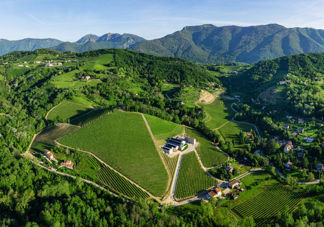 Tenuta Prapian, the Sacchetto family's estate, seen from the air among wooded hills and vineyards