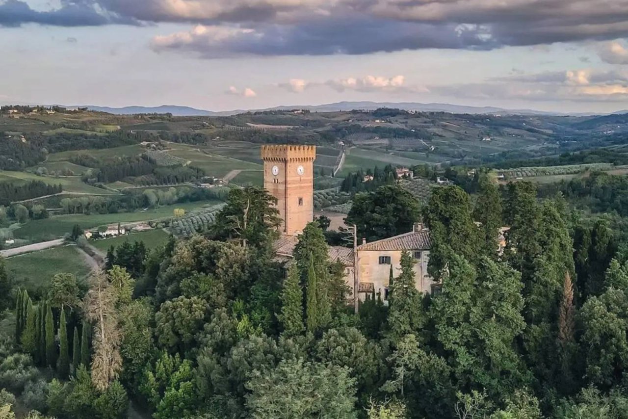 The tower of Castello Sonnino rising among cypresses over the Chianti hills at Montespertoli